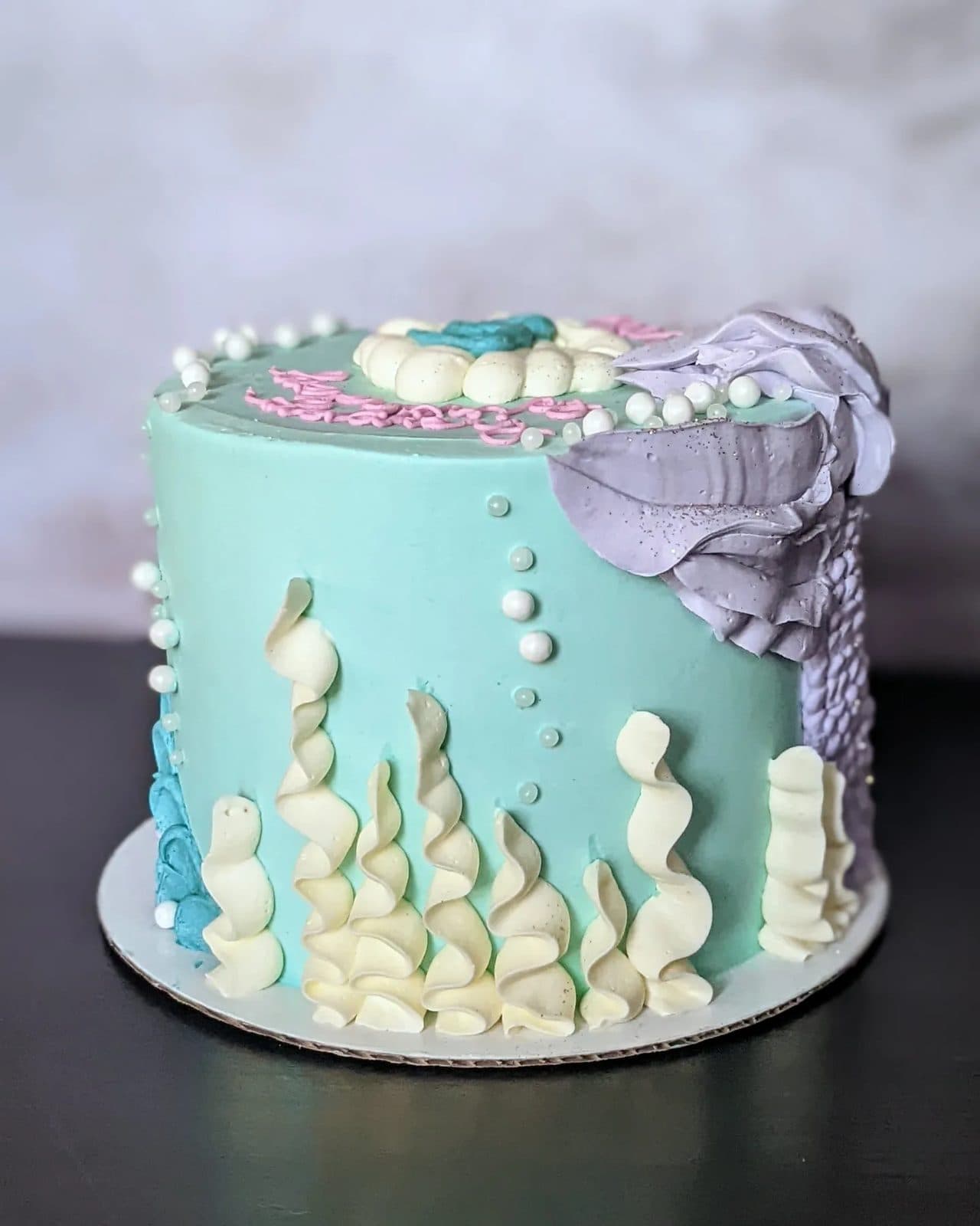 Another view of the mermaid cake, blue waves above and a scaled tail below.