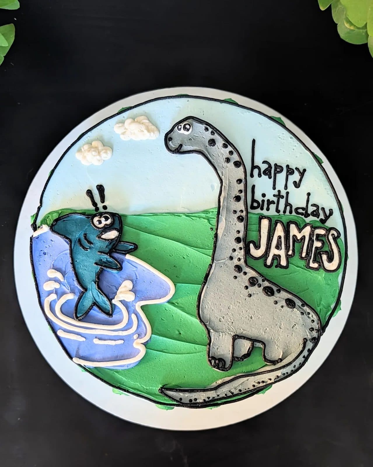 Side view of the fish and the brachiosaurus on the blue wave cake.