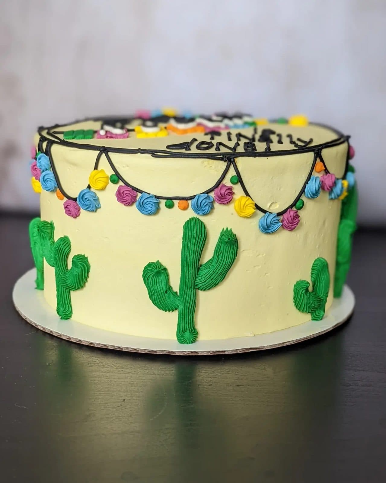 Closer view of the succulent topper, rosettes of green and blue buttercream.