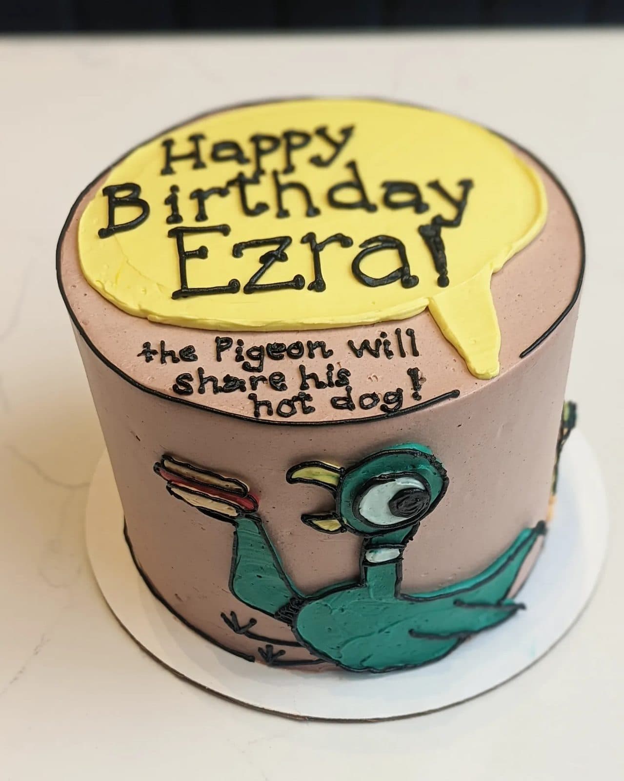 Side view of the pigeon standing over the bus, STOP written in white on the chocolate side.