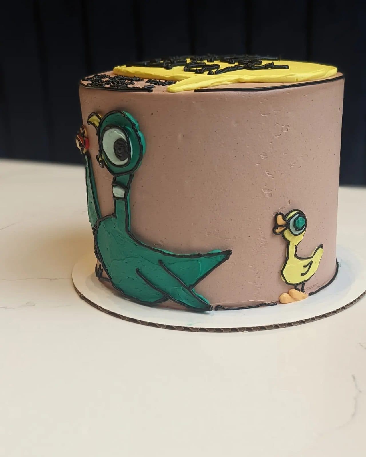 Another view of the pigeon cake with the bus and the word STOP.