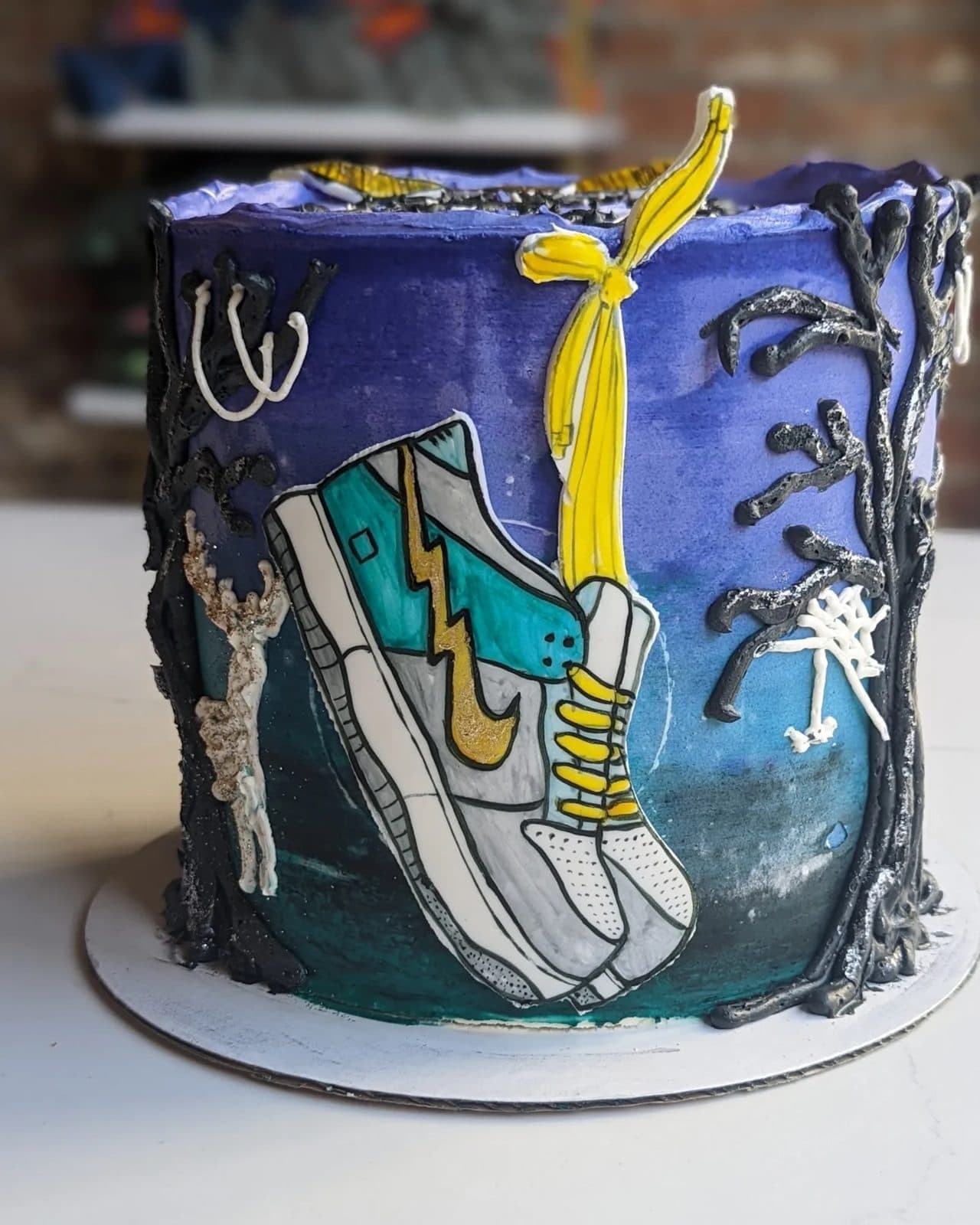 Top of the cake: a golden snitch, stars, and two Nike-style high-tops, one white and one deep blue.