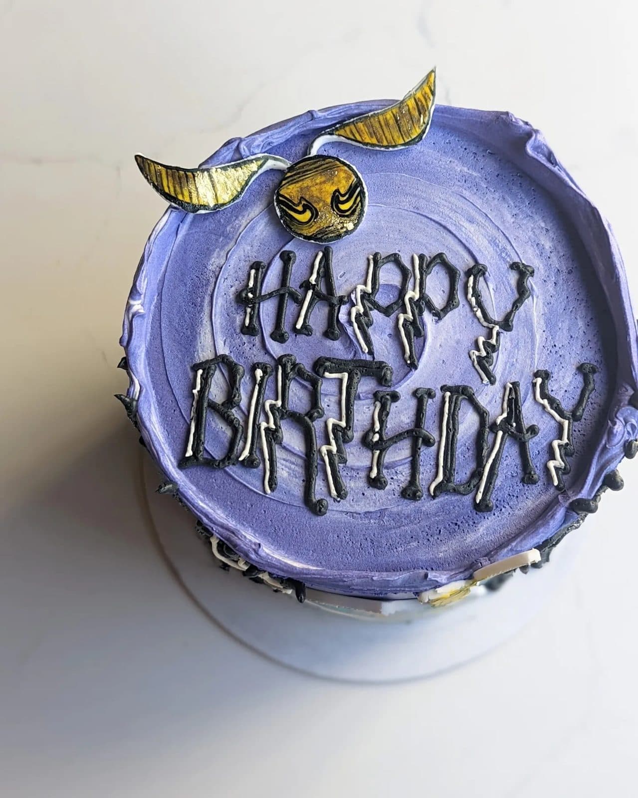 Another view of the dark blue Harry Potter cake with the custom sneakers and golden snitch.