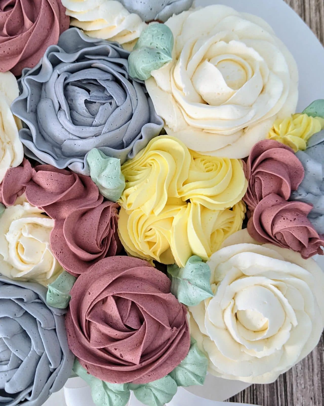Another angle of the piped pink, blue, and white flower cake.