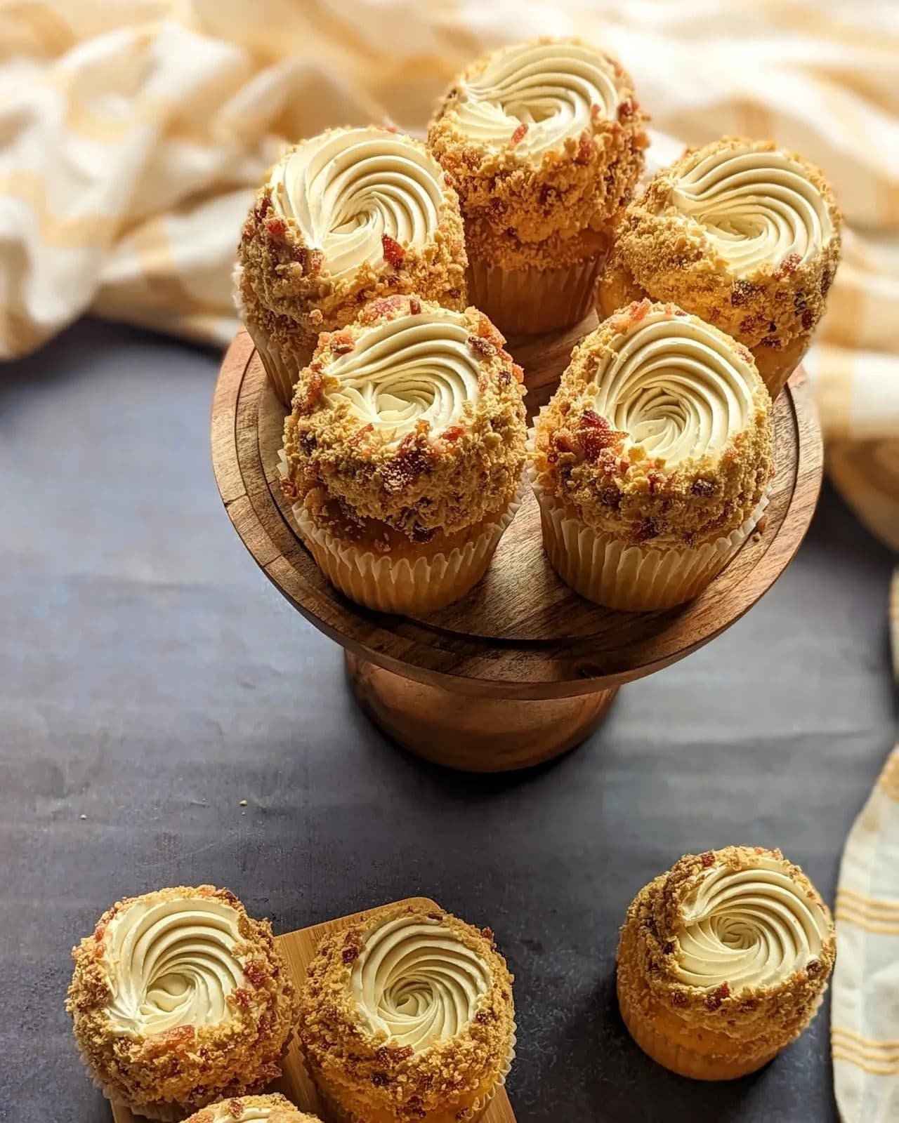 Cupcakes with tall pink, chocolate, and white swirls arranged on the bakery shelf.