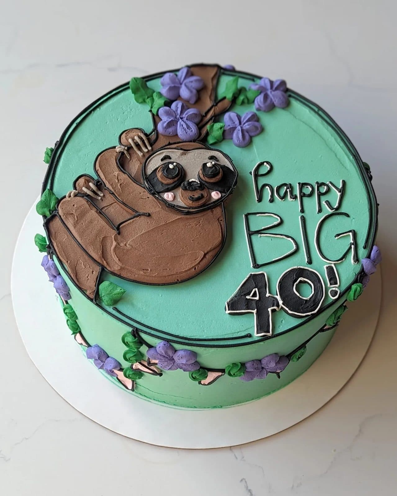 Another cake in the case, finished with piped flowers and a soft colored drip.