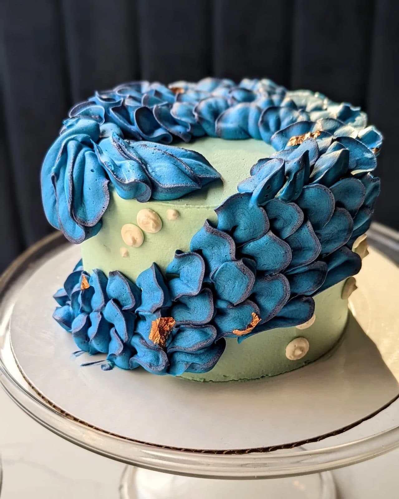A flower-topped cake among the other desserts in the lighted case.