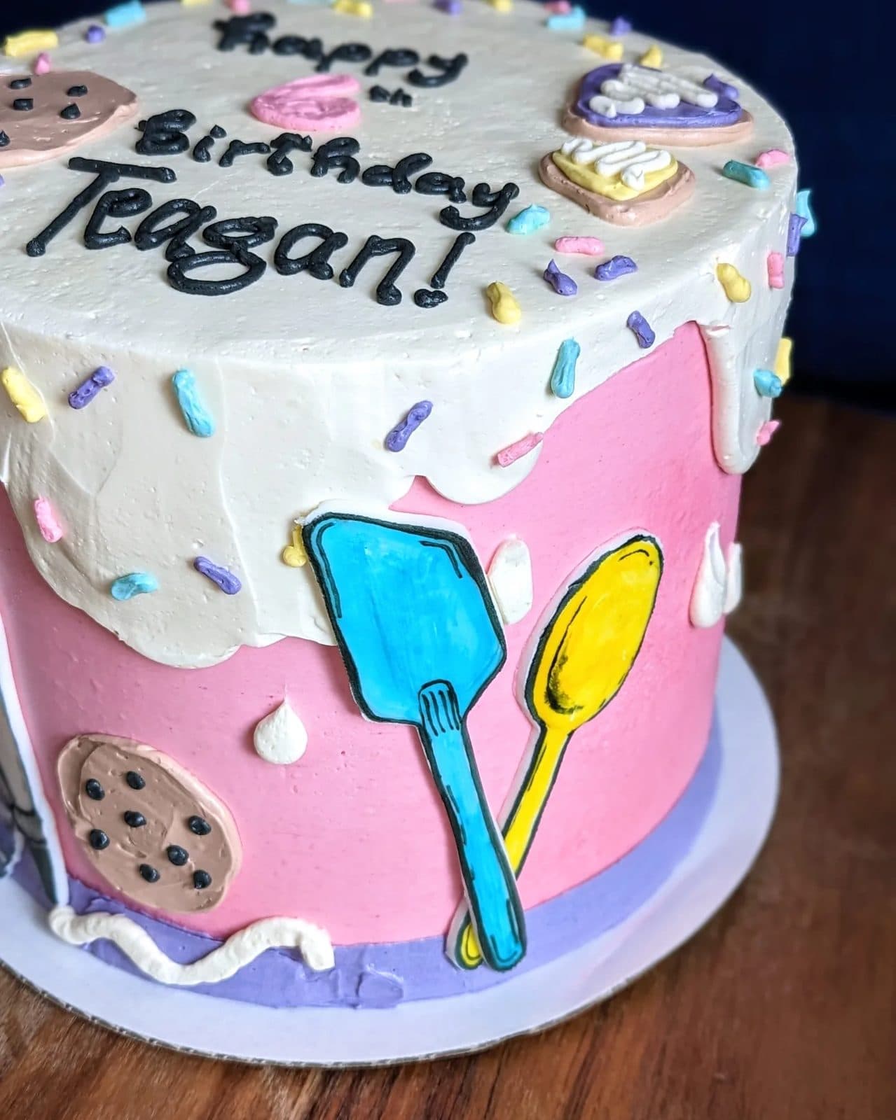 The lower tier, smooth sage-green frosting with a few small flowers at the base.